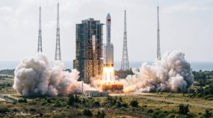 Long March 8A rocket lifting off from a coastal launch tower in clouds of exhaust smoke